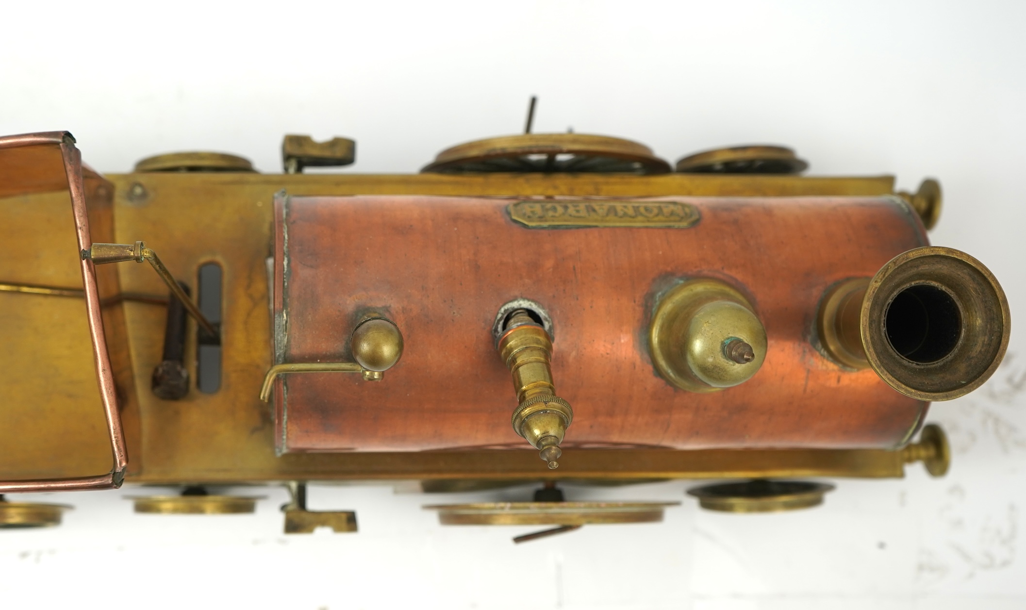 Three late 19th or early 20th century brass and copper live steam locomotives; a 2-2-4, ‘Monarch’, gauged to run on approximately 4 1/2 inch track, 33cm long frames, a 2-2-2, ‘Dragon’, gauged to run on approximately 3 1/